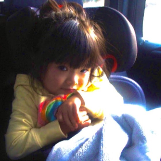 Chloe as a small child, bundled up in a car seat