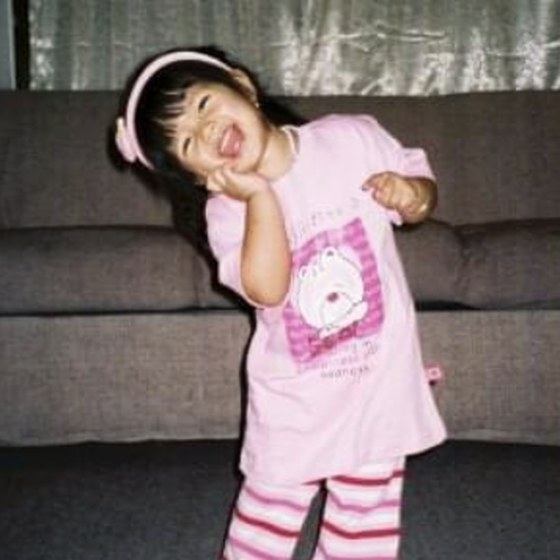 Darlene as a young child in pyjamas, mid-pose in a living room